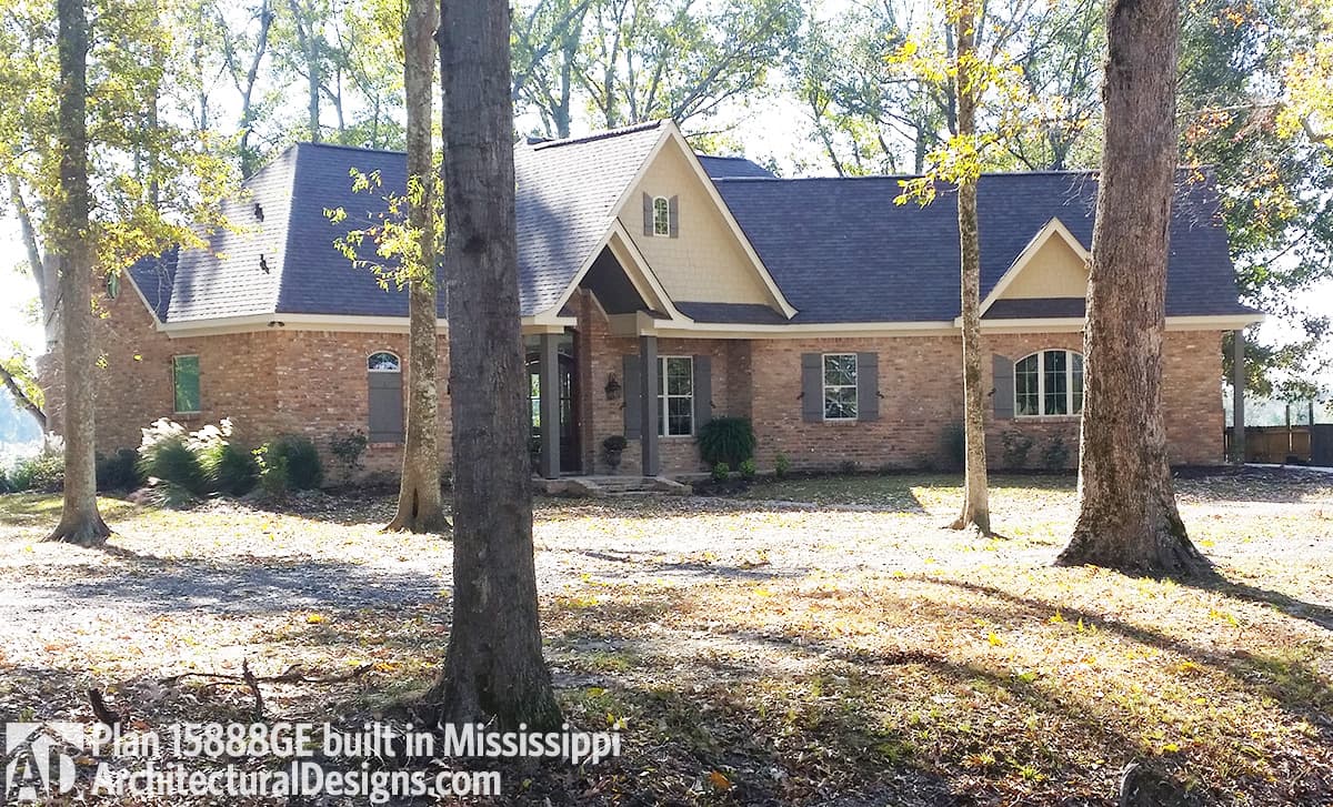 House plan exterior: brick, one-story, prominent gables, covered entry with dormer, arched window.