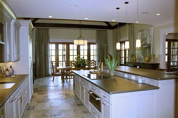 Open concept kitchen and dining area with large island, exposed beams, and french doors.