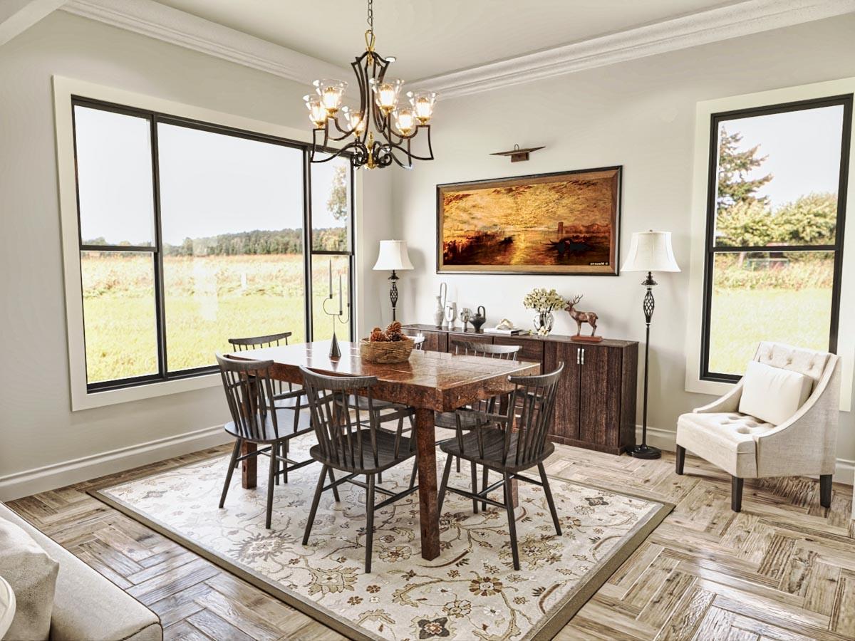 Dining room with a large wooden table, chairs, buffet, and picture windows overlooking a field.