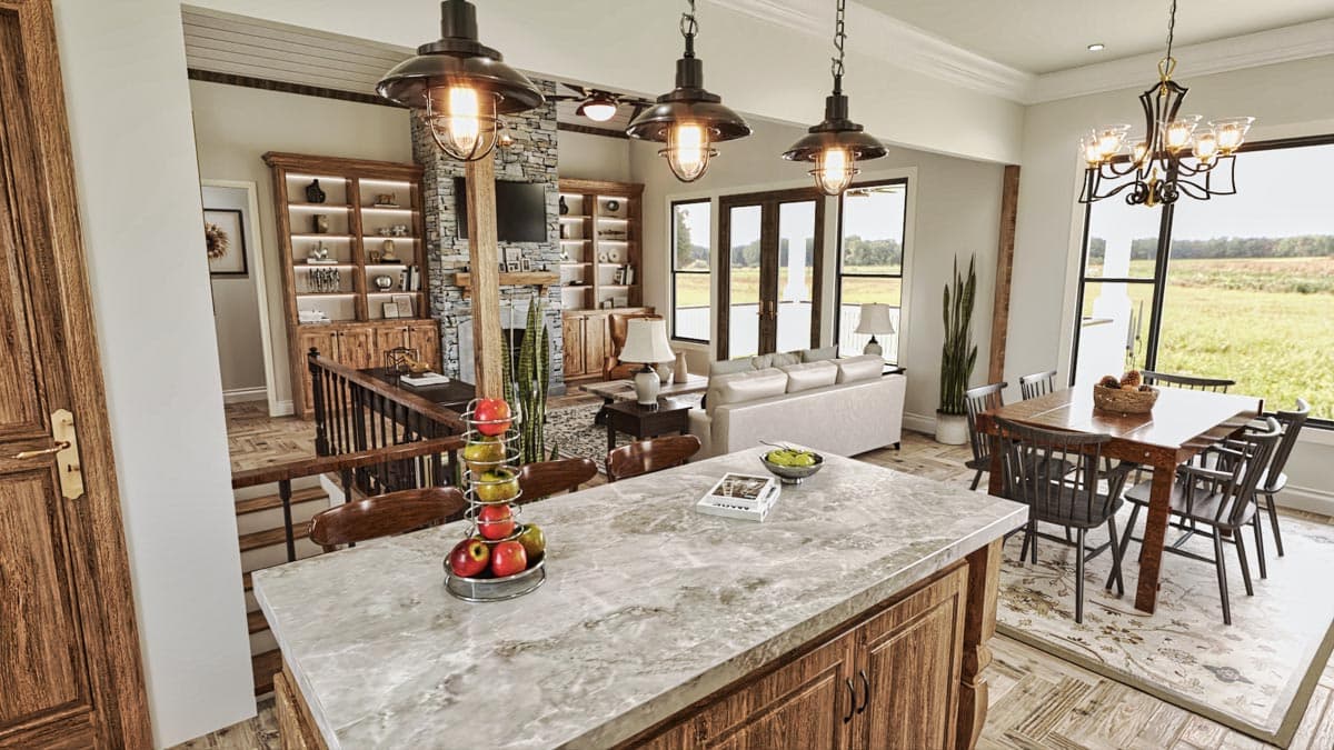 Open concept living and dining area with stone fireplace, built-in shelving, large windows, and kitchen island.
