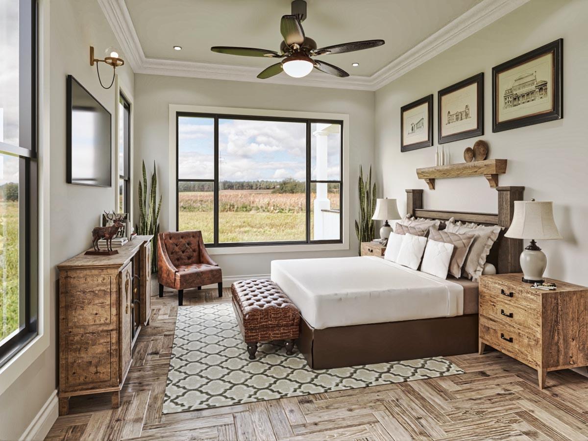 Bedroom with king bed, rustic wood furniture, large picture window overlooking fields, and ceiling fan.