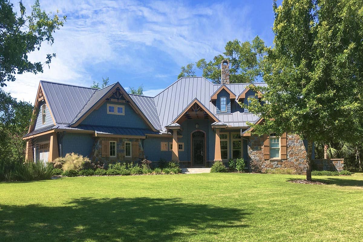 House plan exterior with two stories, Craftsman style, metal roof, gables, dormers, and stone accents.