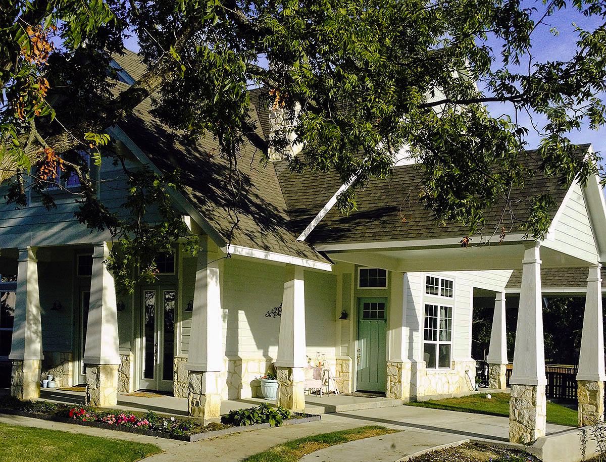 House plan exterior with a covered entry, stone accents, multiple gables, and a single story.