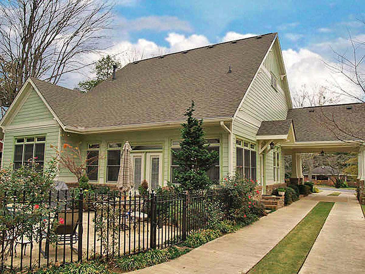 House plan exterior: Light green, one-story dwelling with gables, multiple dormers, and covered carport.
