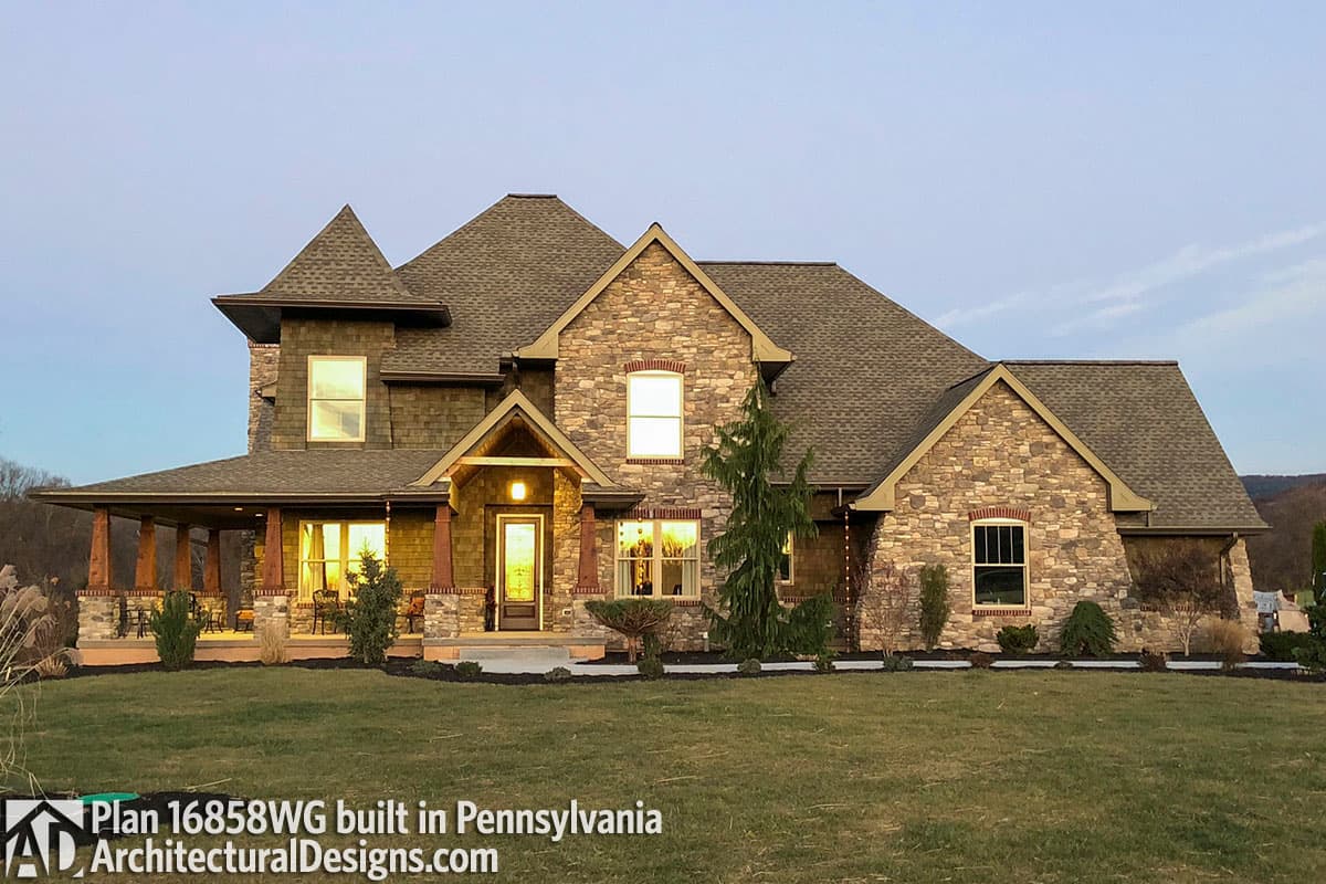 House plan exterior with stone and shingle siding, wraparound porch, and multiple gables.