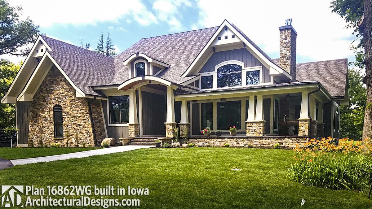 House plan exterior: Stone and siding, gabled dormers, covered porch with stone supports, and a prominent stone chimney.