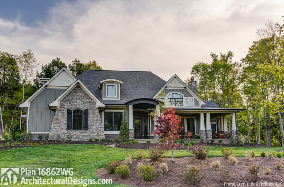 House plan exterior: Traditional home with stone and siding, prominent gable, dormer, and covered front porch.
