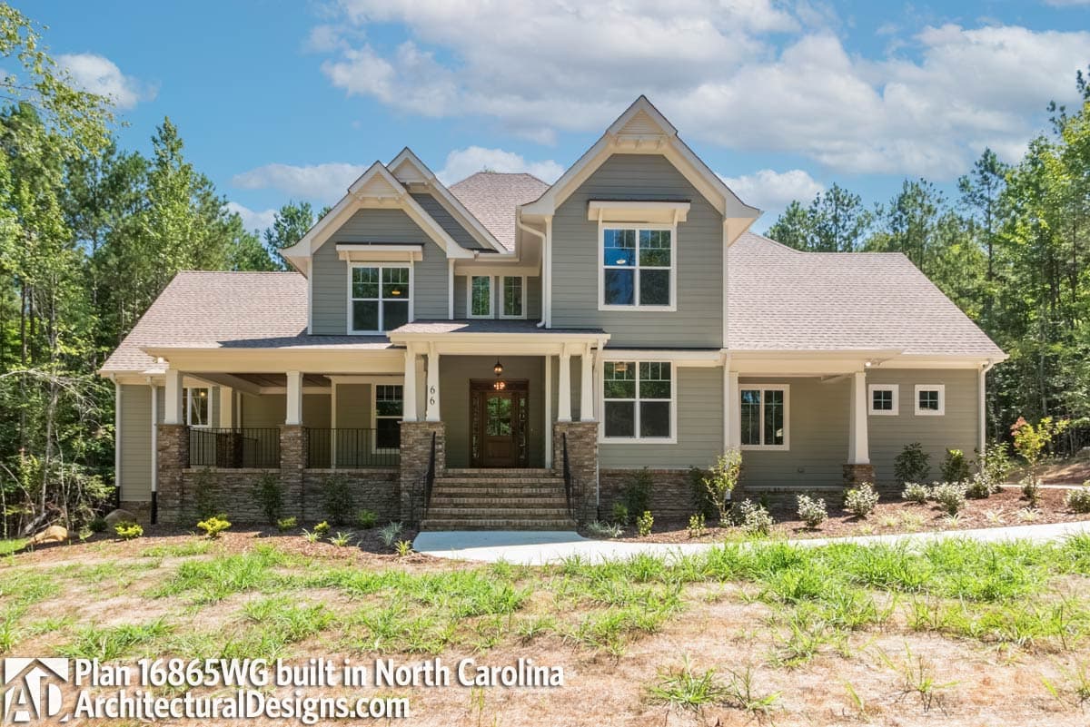 House plan exterior: Two-story Modern Farmhouse with wraparound porch, stone accents, and multiple gables.
