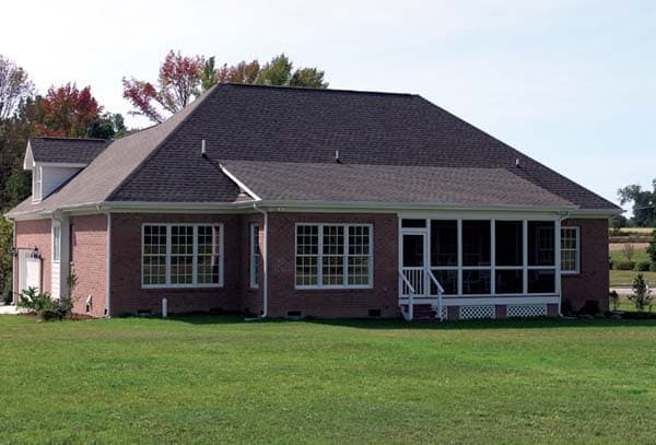 House plan exterior: Brick ranch with hip roof, attached garage, and large screened porch with white railings.