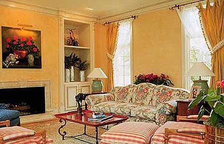 Living room with fireplace, built-in shelving, floral sofa, and ornate coffee table.