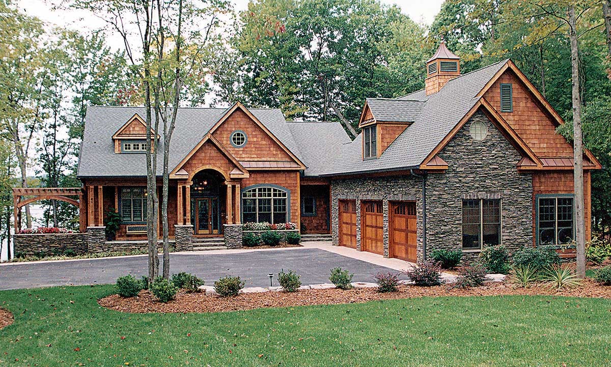 Craftsman style house plan exterior with stone and wood siding, covered entry porch, and a three-car garage.