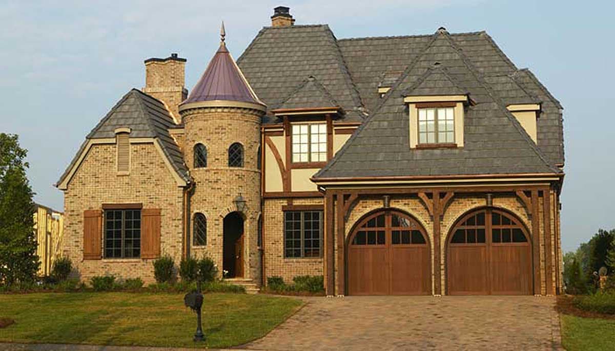 House plan exterior with turret, arched garage doors, and slate roof. Features include gables, dormers, and brick facade.