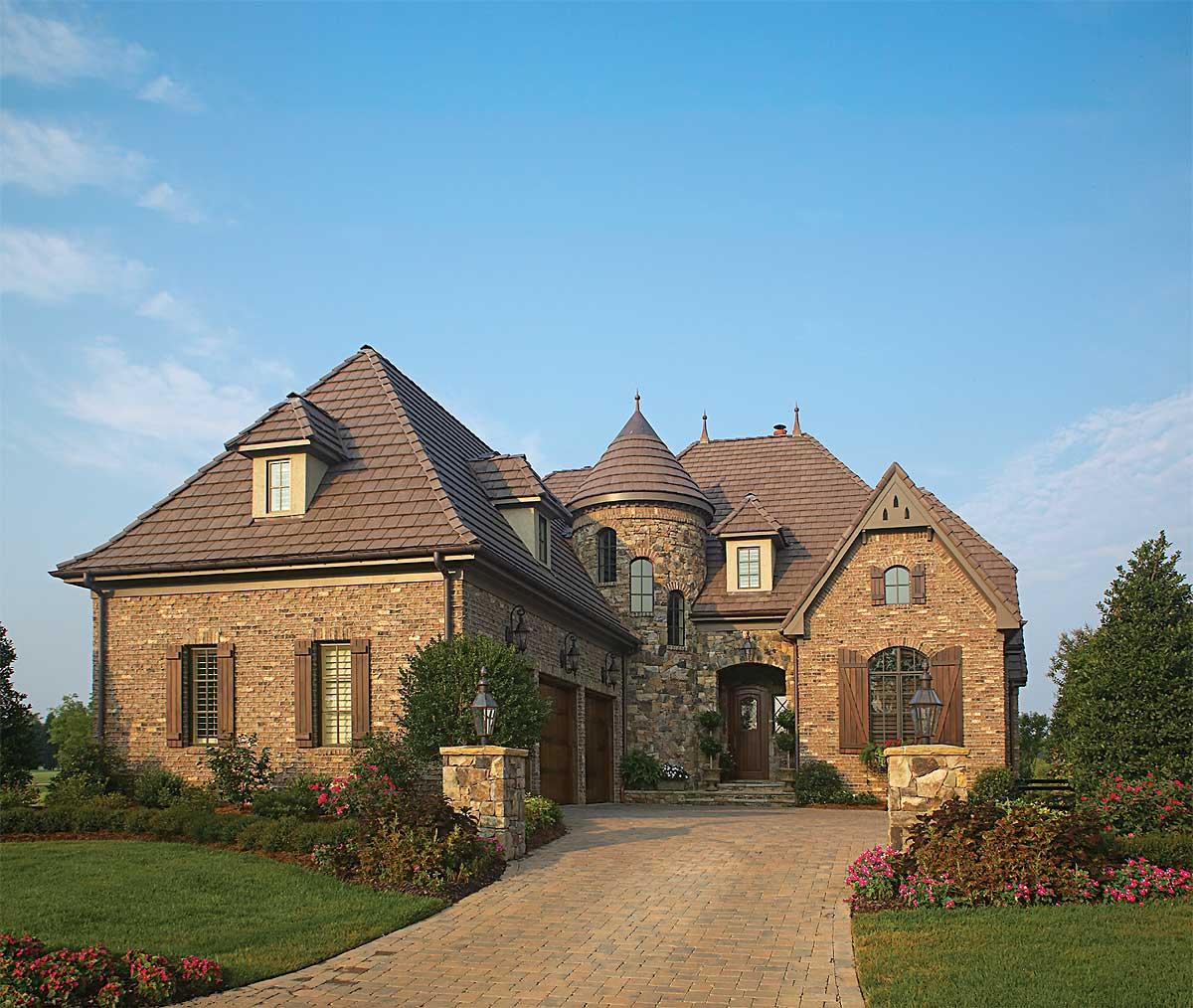 House plan exterior with brick facade, turret, multiple gables, dormers, and attached garage.