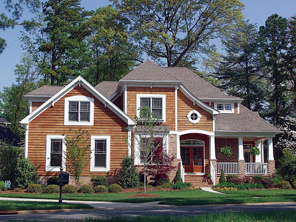 House plan exterior: two-story dwelling with cedar shingle siding, gables, dormers, and covered front porch.