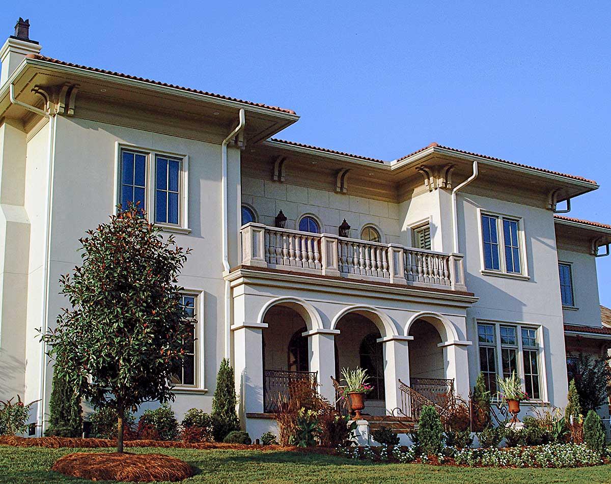 House plan exterior shows a two-story Mediterranean-style home with a loggia, balustrade balcony, and arched entryway.