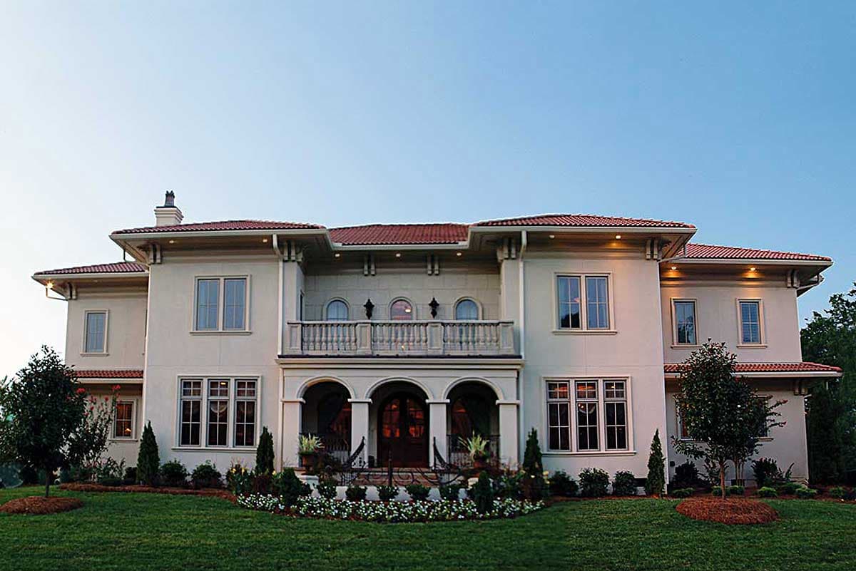 House plan exterior with Mediterranean style, two stories, arched entry porch, balcony with balustrade, and tile roof.