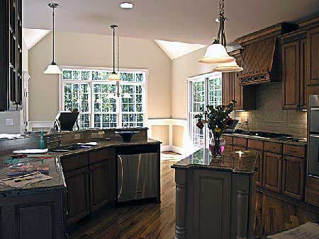 Kitchen with large island, granite countertops, dark wood cabinets, and large bay window.