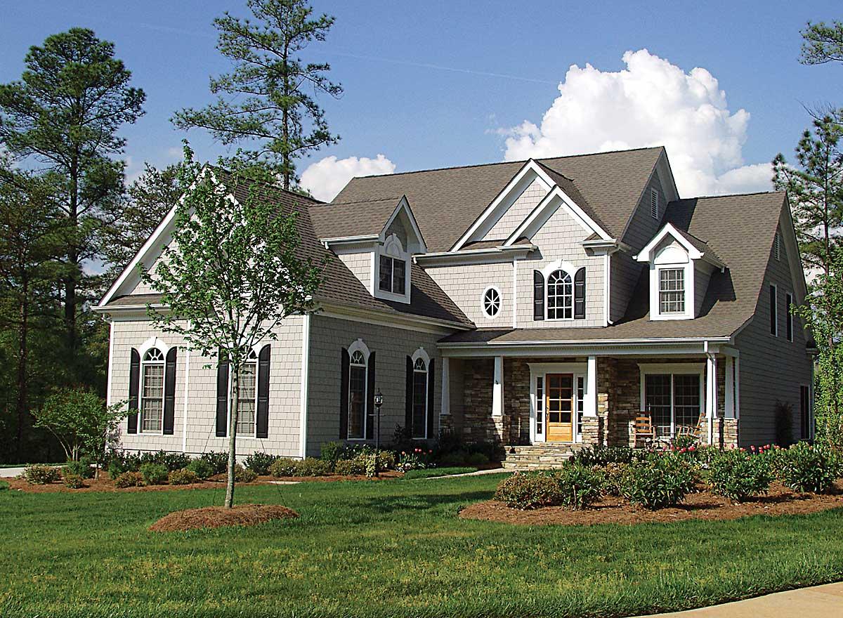 House plan exterior: Two-story Modern Farmhouse with stone accents, gabled dormers, covered porch, and multi-pane windows.