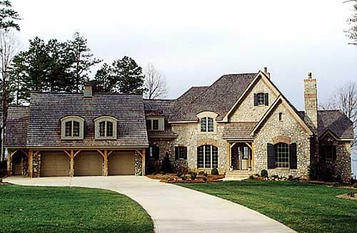 House plan exterior: Stone two-story home with a three-car garage, arched windows, dormers, and cedar shake roof.