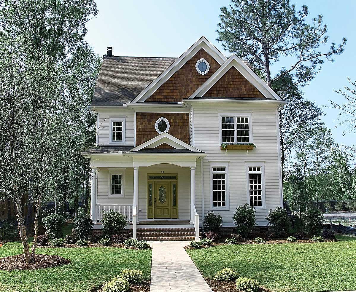 House plan exterior of a two-story home with a covered porch, prominent gables, shingle accent, and dormer windows.