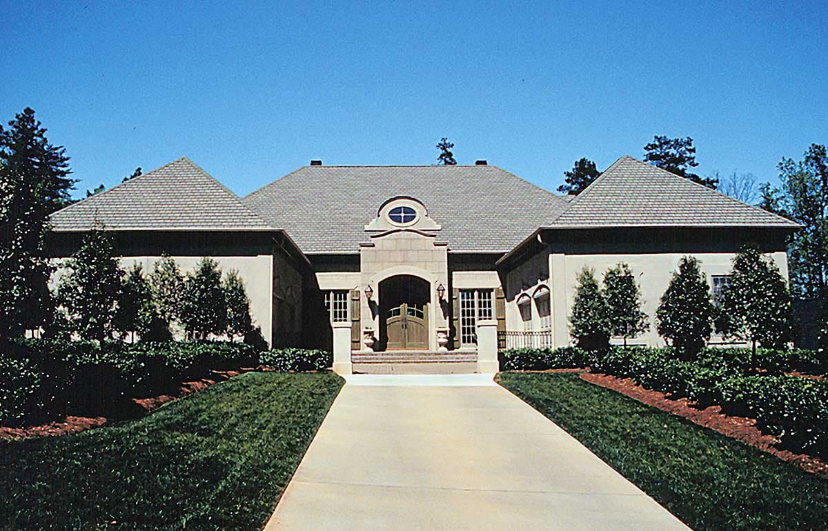 House plan exterior: Wide, central entrance with arched double doors, flanked by tall windows and symmetrical gables.