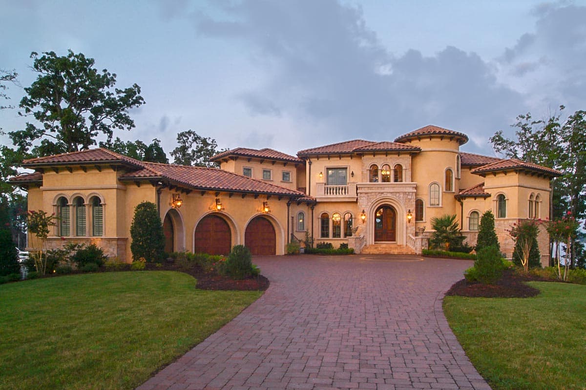 House plan exterior: Italian Renaissance style, multiple gables, arched garage doors, and a prominent arched entryway with a balcony.
