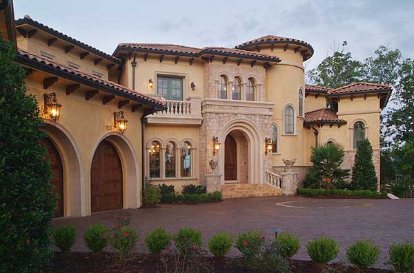 House plan exterior: Italian Renaissance style, two-story, arched garage doors, rounded turret, stone accents, and tile roof.