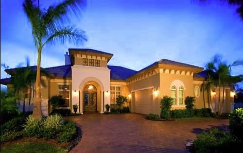 House plan exterior of a one-story Mediterranean style home with arched entryway, hip roof, and attached garage.