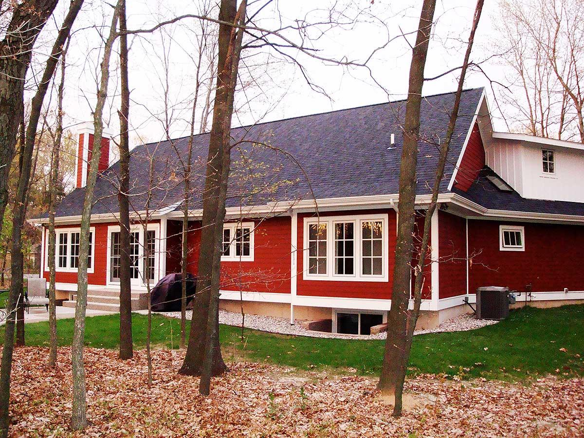 House plan exterior: Red-sided two-story home with a gabled roof, multiple windows, and a brick chimney.