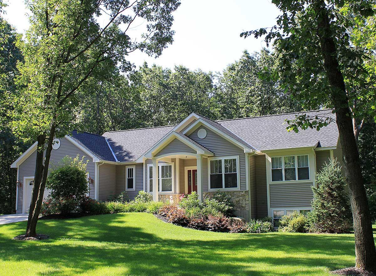 House plan exterior: One-story Ranch with gable, dormer, stone accents, and side-facing garage.