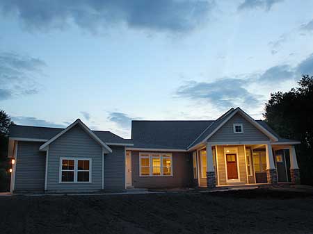 House plan exterior: Ranch style with gabled front porch, stone accents, and vinyl siding.