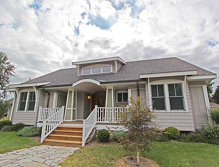 House plan exterior: One-story Craftsman home with a covered porch, gabled dormers, and a hip roof.