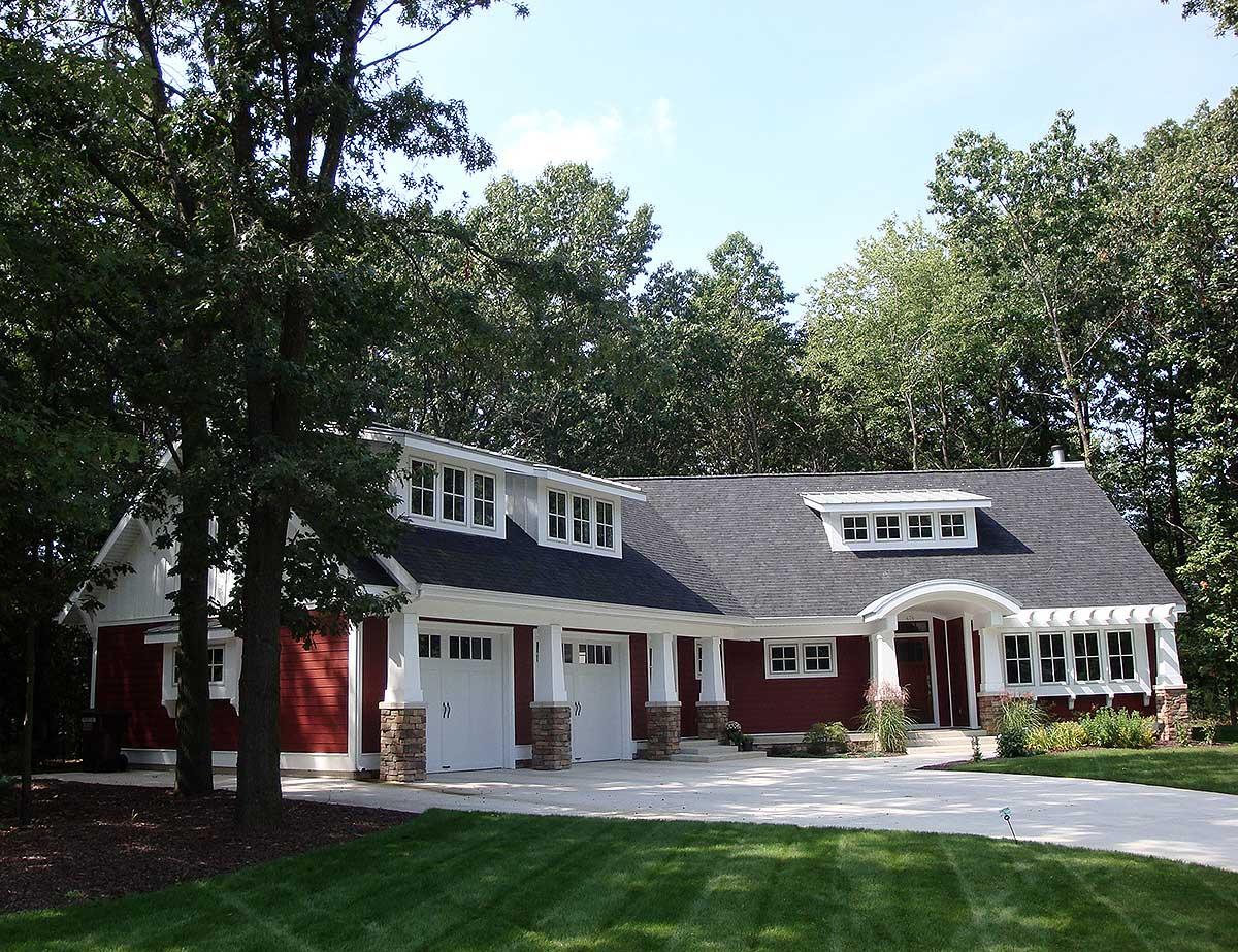 House plan exterior with a detached three-car garage, gables, dormers, and stone accents.