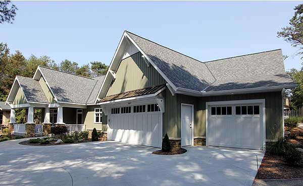 House plan exterior: Modern Farmhouse style, one story, with a covered porch, multiple gables, and a three-car garage.