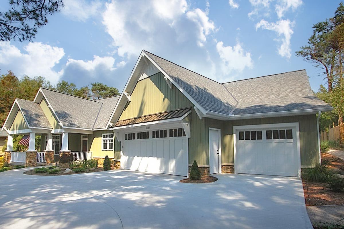 House plan exterior with two-car garage, gabled roof, covered front porch with stone accents, and multiple dormers.