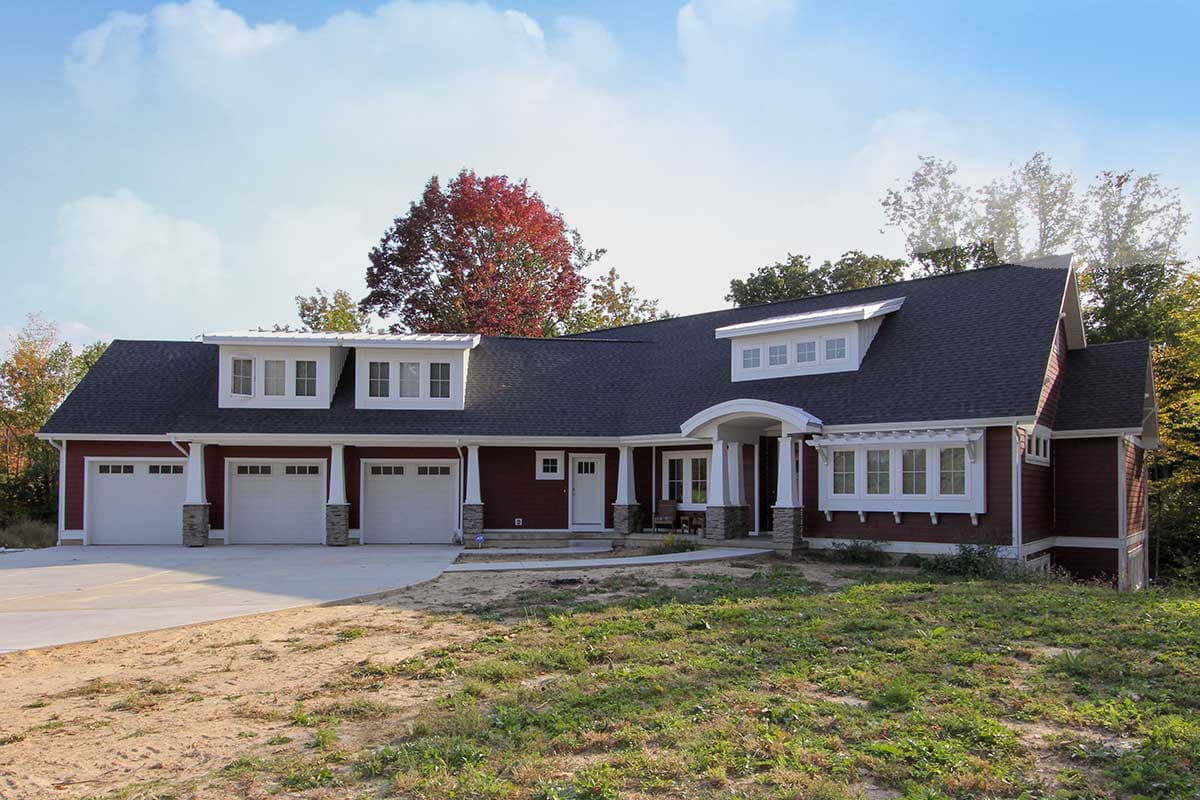 House plan exterior: Modern Farmhouse style, one-story with three-car garage, prominent gables, and arched entry.