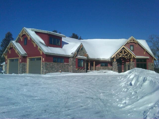 House plan exterior with Craftsman details: two-story, gabled roof, stone accents, porte-cochere, and attached garage.