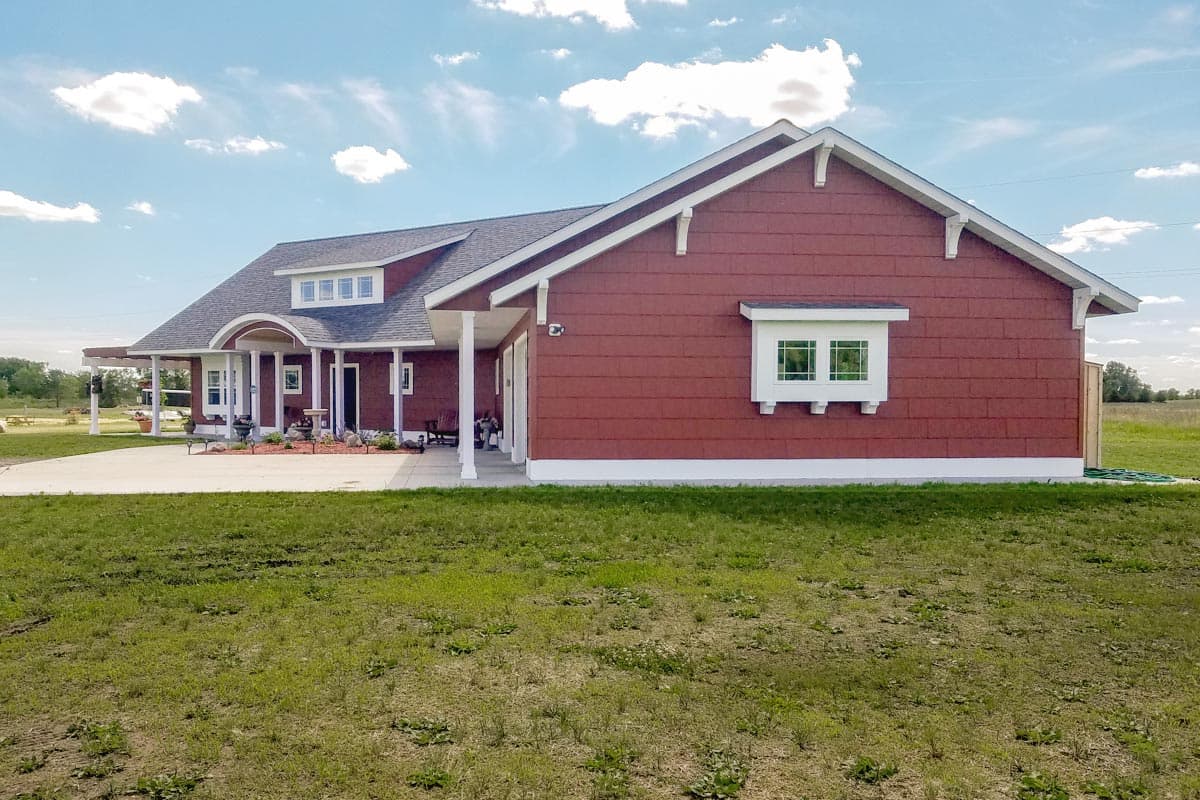 House plan exterior: One-story Modern Farmhouse with gabled roof, covered porch with columns, and a dormer with multiple windows.