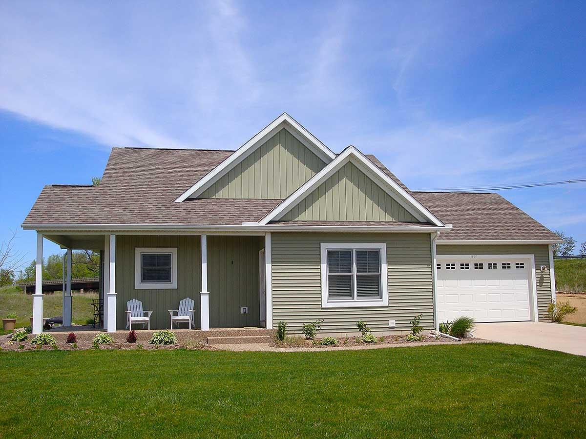 House plan exterior: One-story modern farmhouse with a covered front porch, prominent gables, and attached two-car garage.