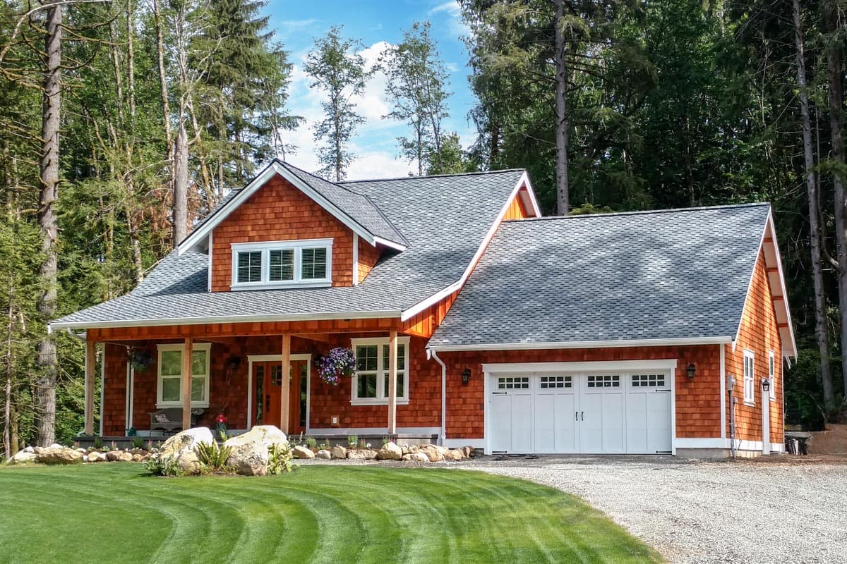 House plan exterior. Craftsman style, two stories. Features include a covered porch, gabled rooflines, and a two-car garage.