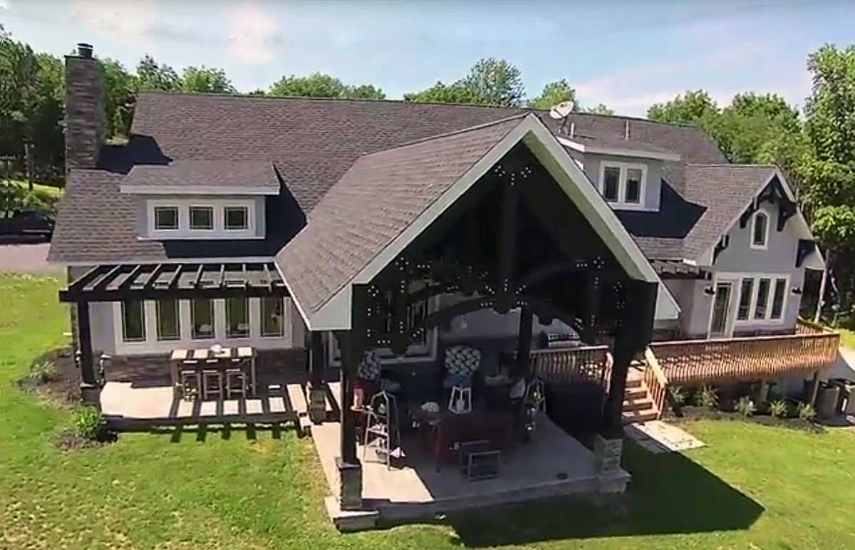 House plan exterior featuring a multi-story structure with gables, a prominent covered patio, and a pergola.