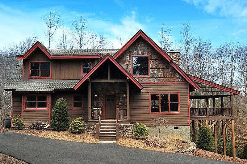 House plan exterior: two-story lodge-style home with prominent gables, stone accents, and covered porch.