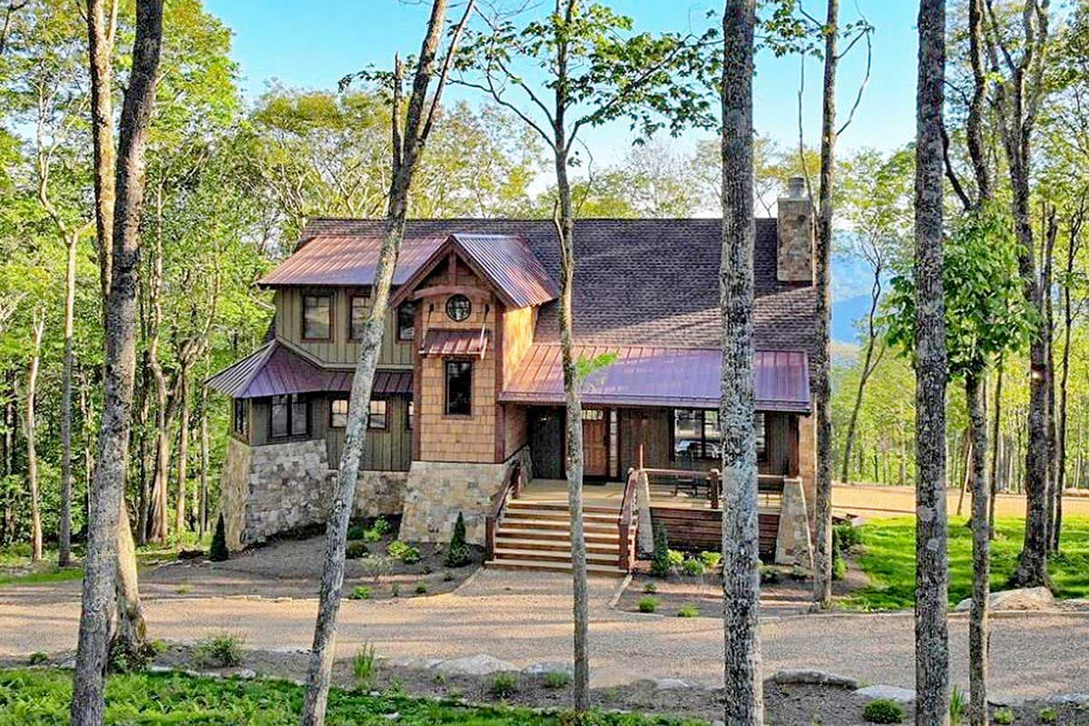 House plan exterior: Two-story mountain-style home with stone foundation, wood siding, metal roof, and covered porch.