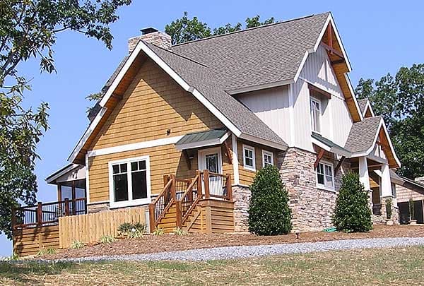 House plan exterior of a multi-story home with stone and shingle siding, gables, dormers, and a covered front porch.