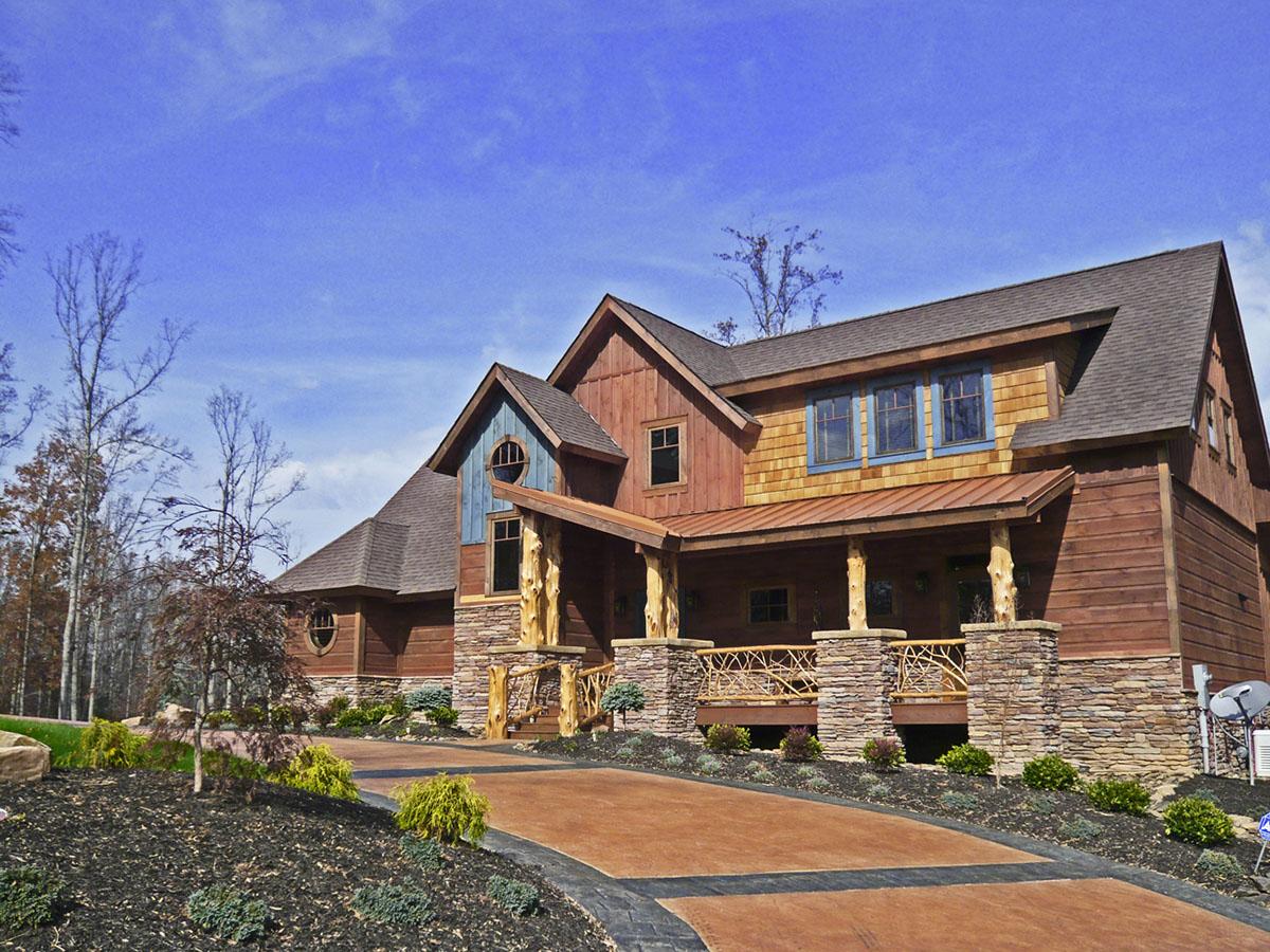 House plan exterior: Lodge style, multi-story, with stone base, wood siding, covered porch, and prominent gables.