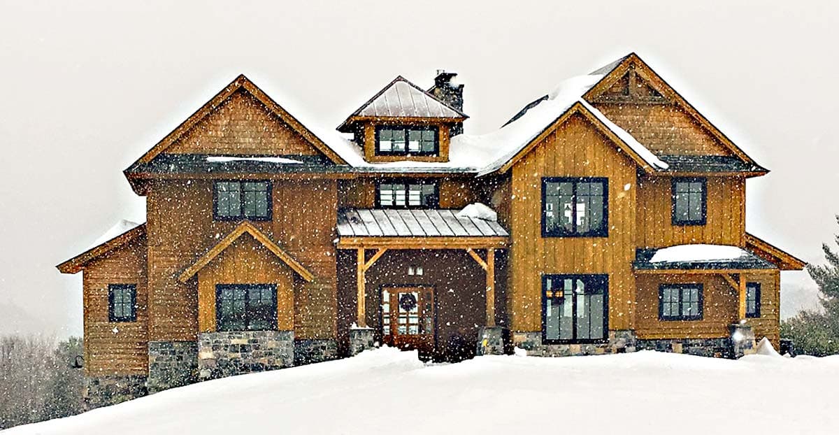 House plan exterior: Two-story timber-clad home with stone accents, prominent gables, dormer, and covered entryway.