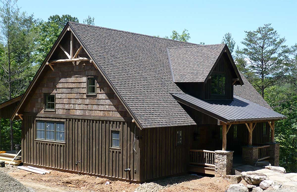 House plan exterior. Two-story Craftsman style home with gabled roof, dormers, and covered porch with exposed timber supports.