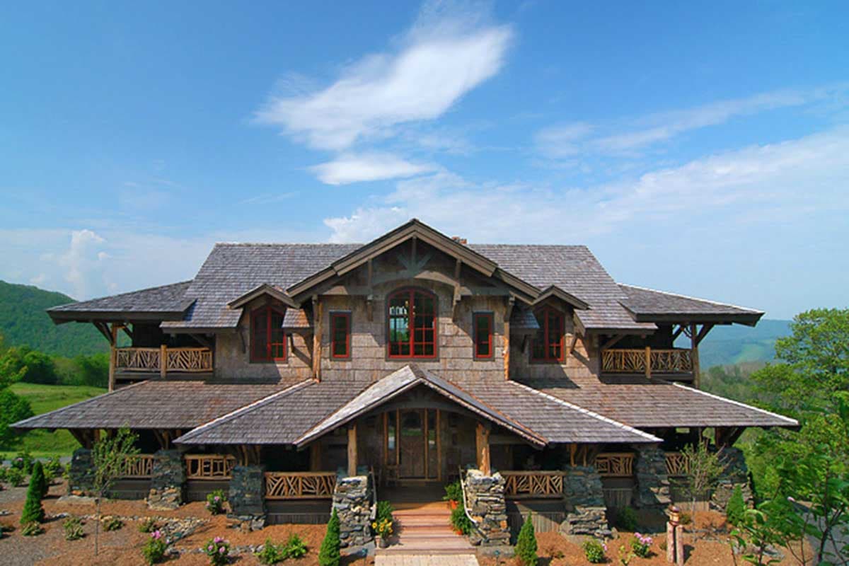 Craftsman style house plan exterior with multiple gables, wood shake siding, stone foundation, and covered porches.