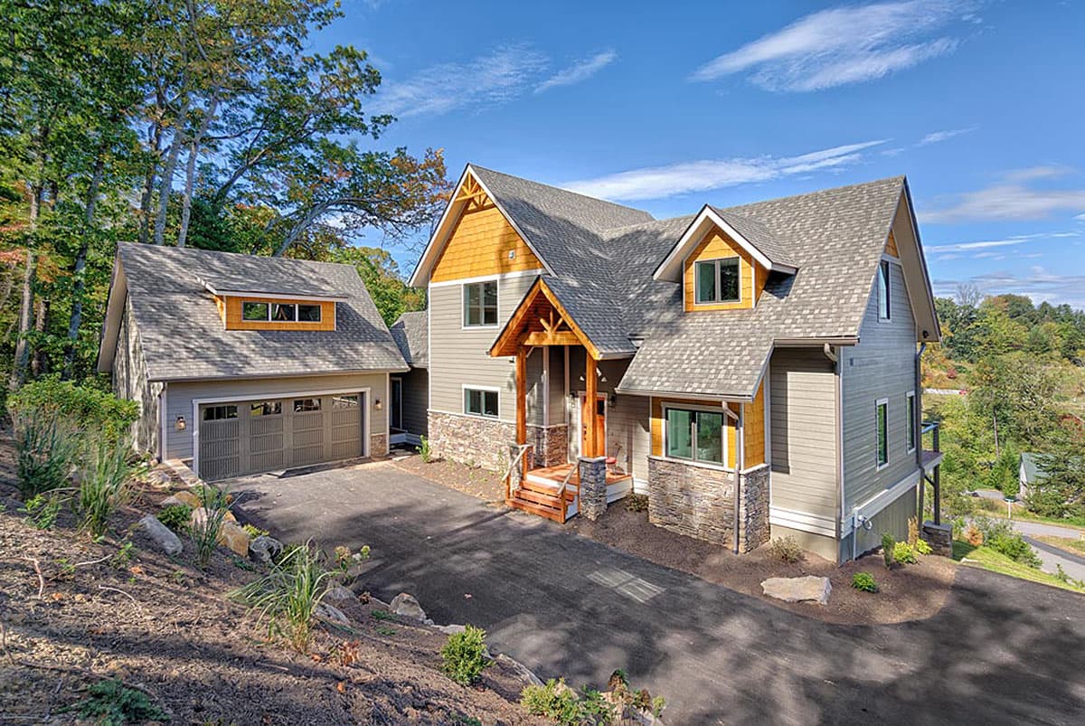 House plan exterior. Two-story home with Craftsman-style elements, multiple gables, a front porch, and a detached garage.