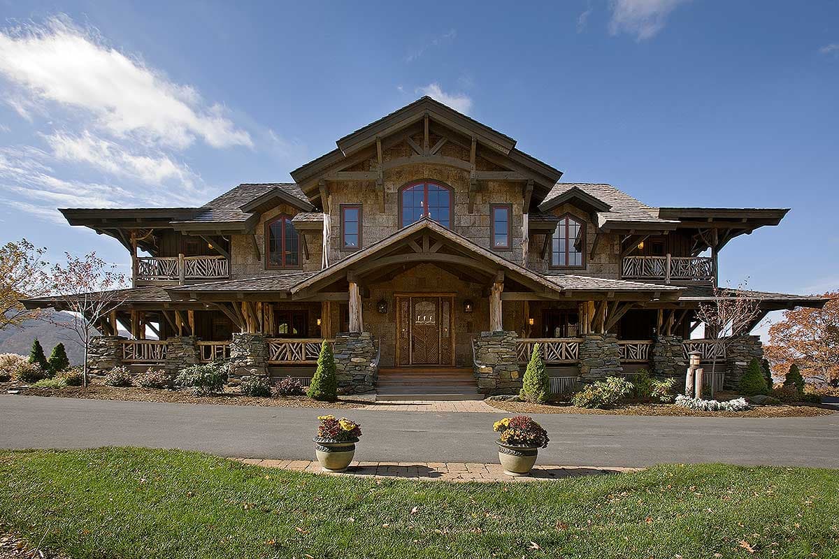 Craftsman style house plan exterior with multiple gables, wide eaves, stone foundation, and wrap-around porches.